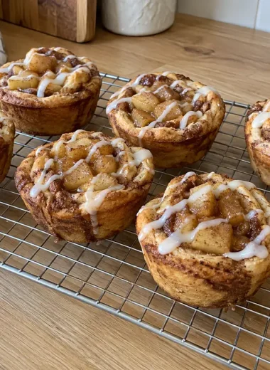 Cinnamon Roll Apple Pie Cups – golden cinnamon roll cups filled with apple pie filling and drizzled with icing on a cooling rack